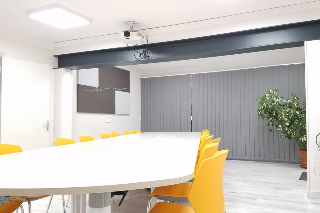 Transformation d’une salle de réunion à Mollégès avec table modulable Fold, chaises Frill jaunes et panneaux acoustiques Serenity personnalisés pour OMAG