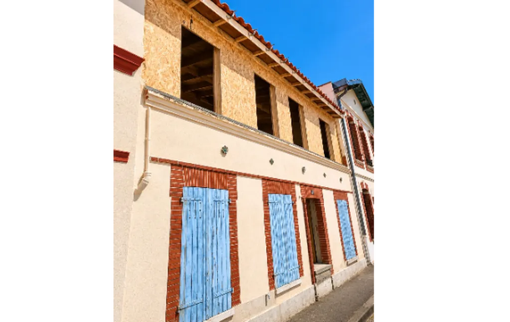 Surélévation ossature bois et charpente traditionnelle avec couverture tuiles terre cuite à Toulouse en rénovation urbaine
