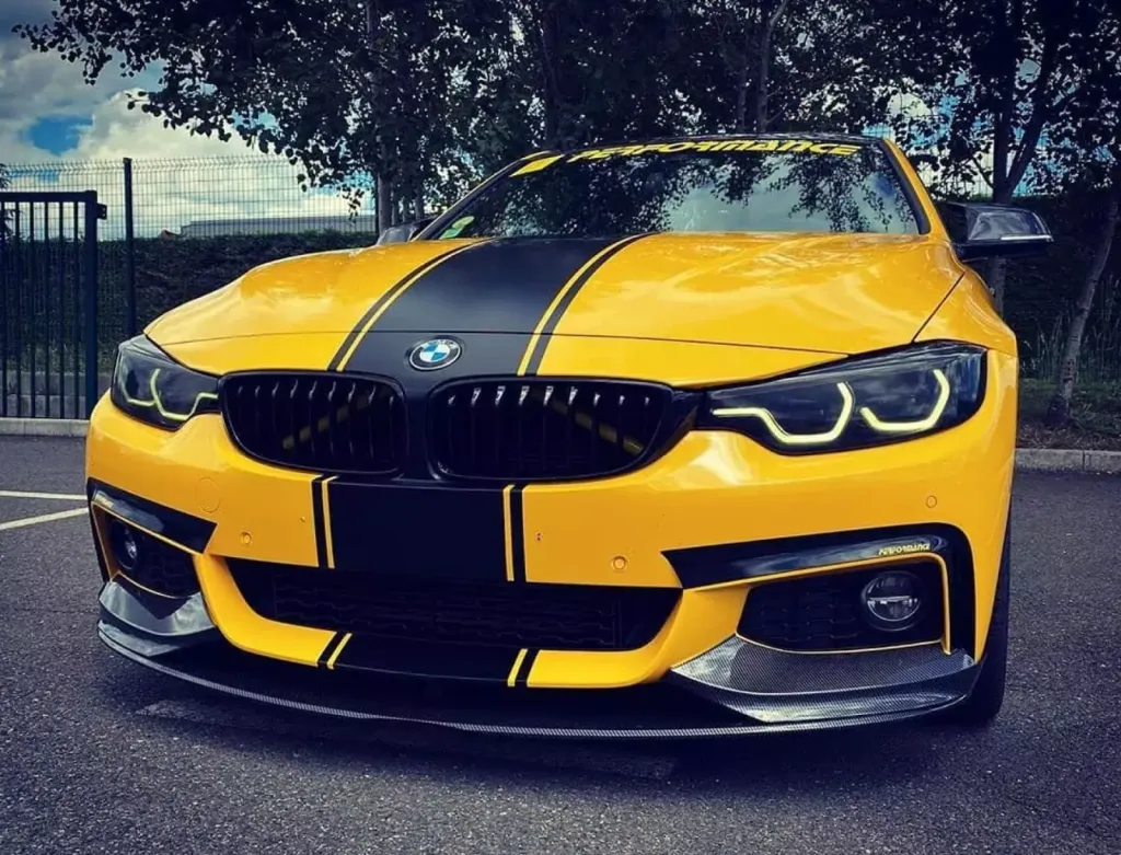 Réalisation d'un covering jaune brillant et des bandes noir satin de chez 3M sur une BMW à Saint-Etienne