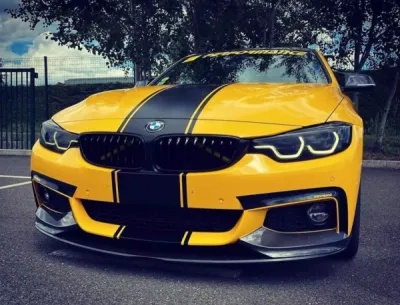 Réalisation d'un covering jaune brillant et des bandes noir satin de chez 3M sur une BMW à Saint-Etienne