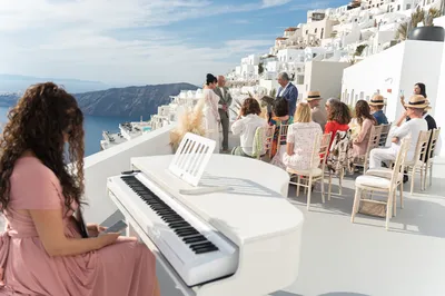 Une cérémonie de mariage civile romantique organisée sur la terrasse d'un hôtel de luxe avec vue sur la Caldera à Santorin