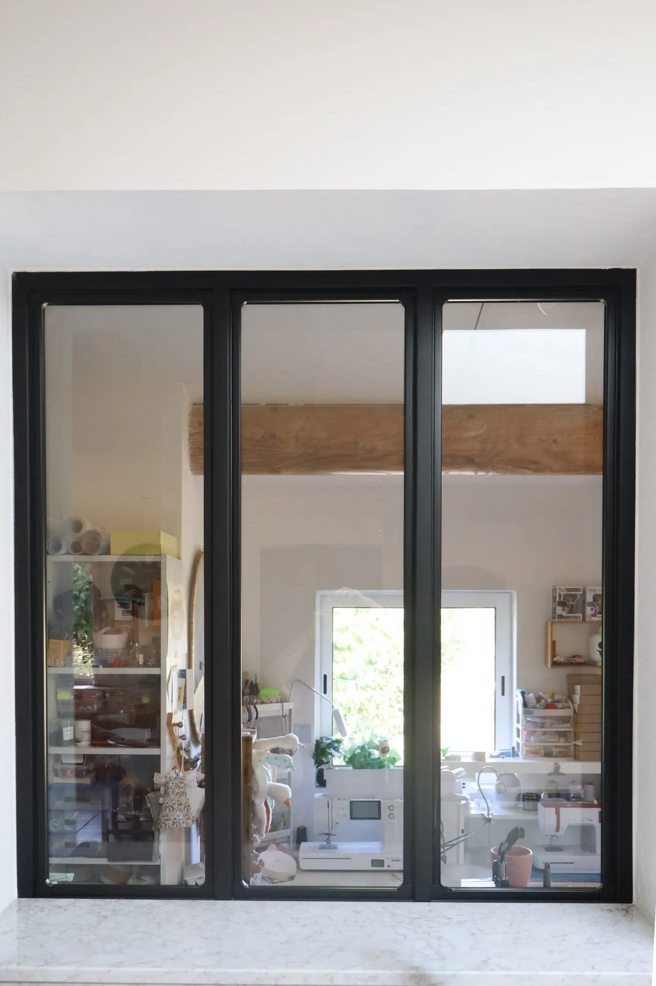 Verrière sur mesure pour apporter une luminosité naturelle entre une cuisine et un espace de travail