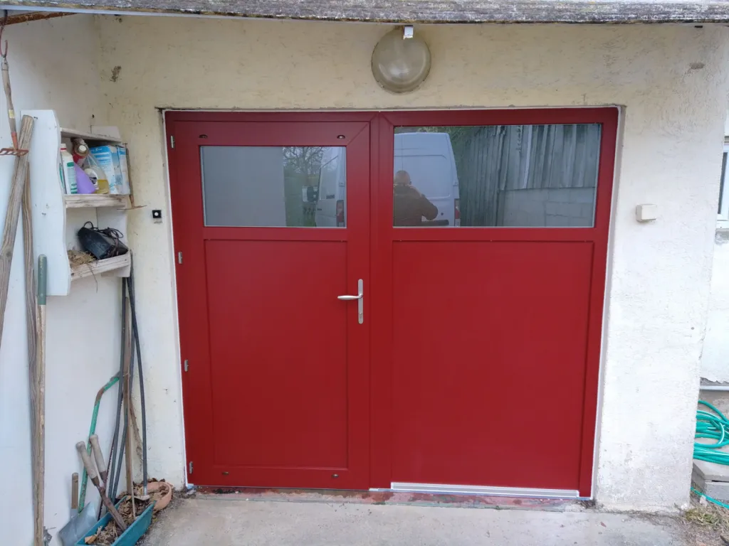 Pose en rénovation d’une porte d’entrée en PVC rouge avec panneau latéral et vitrage à Mérignac