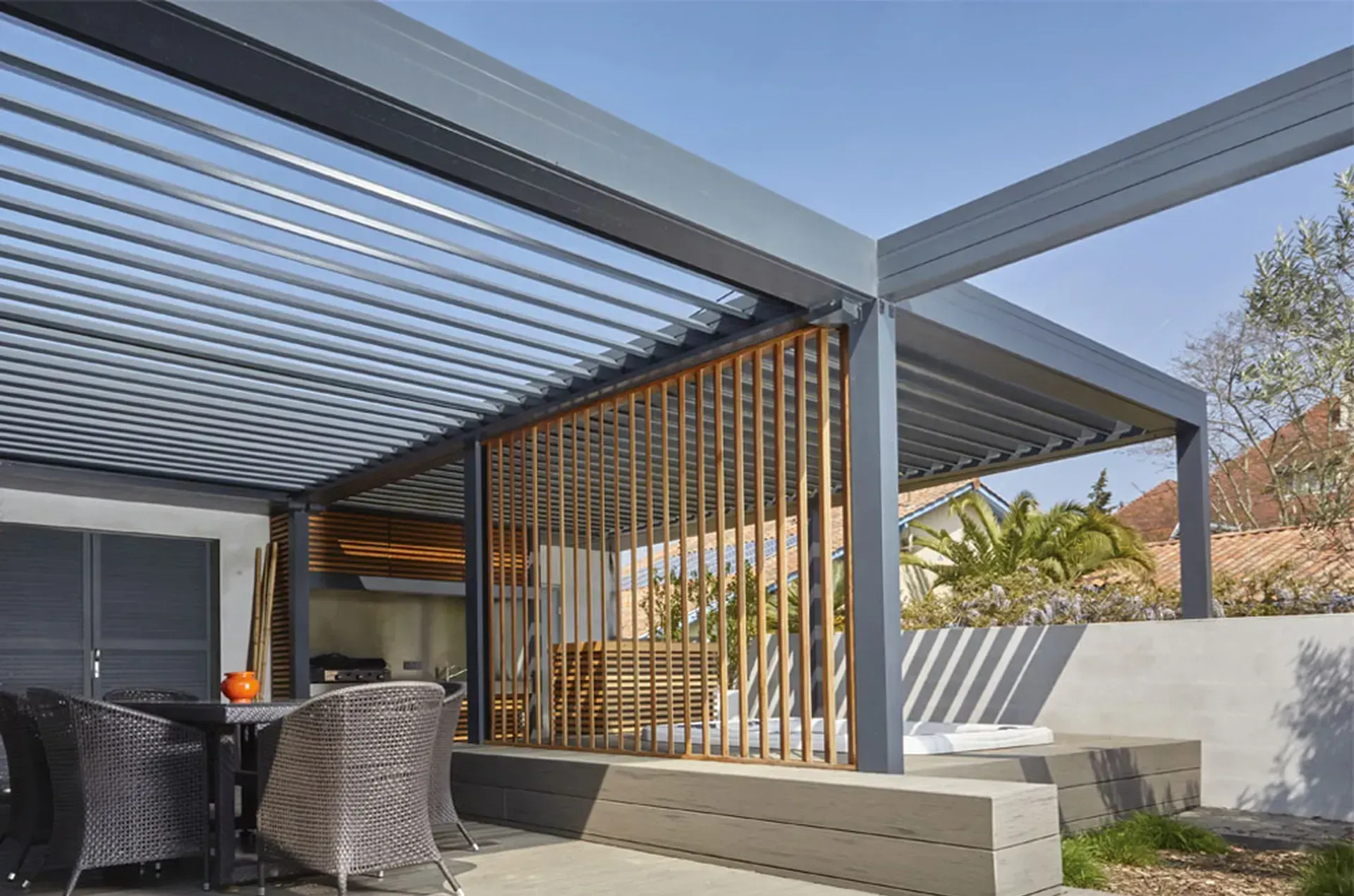 Pergola bioclimatique gris en aluminium et claustra bois