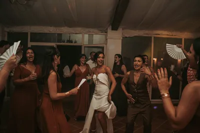 La mariée sur la piste de danse, entourée de ses proches, dans l'élan d'une soirée de mariage.