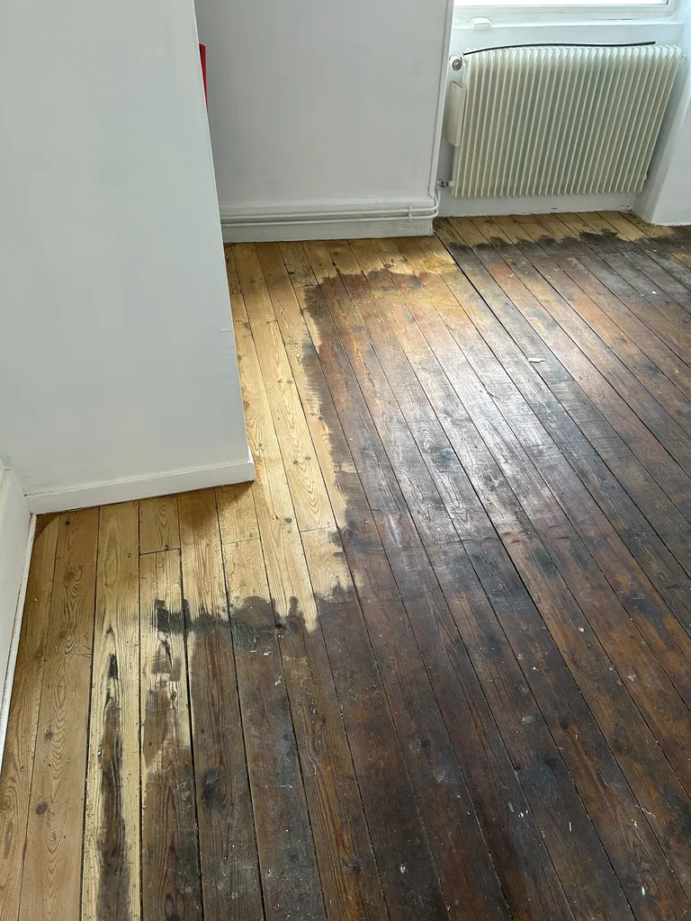 Ponçage du parquet en cours dans le salon lors des travaux de rénovation
