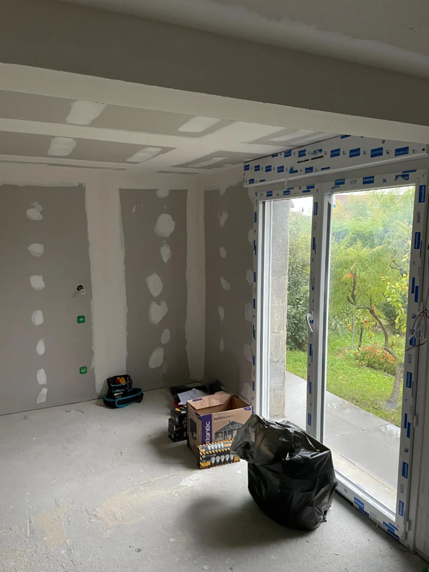 Baie vitrée après isolation thermique intérieure (ITI) avant travaux de peinture, garantissant une finition propre et une performance thermique optimale à Belleville-en-Beaujolais (Rhône 69)