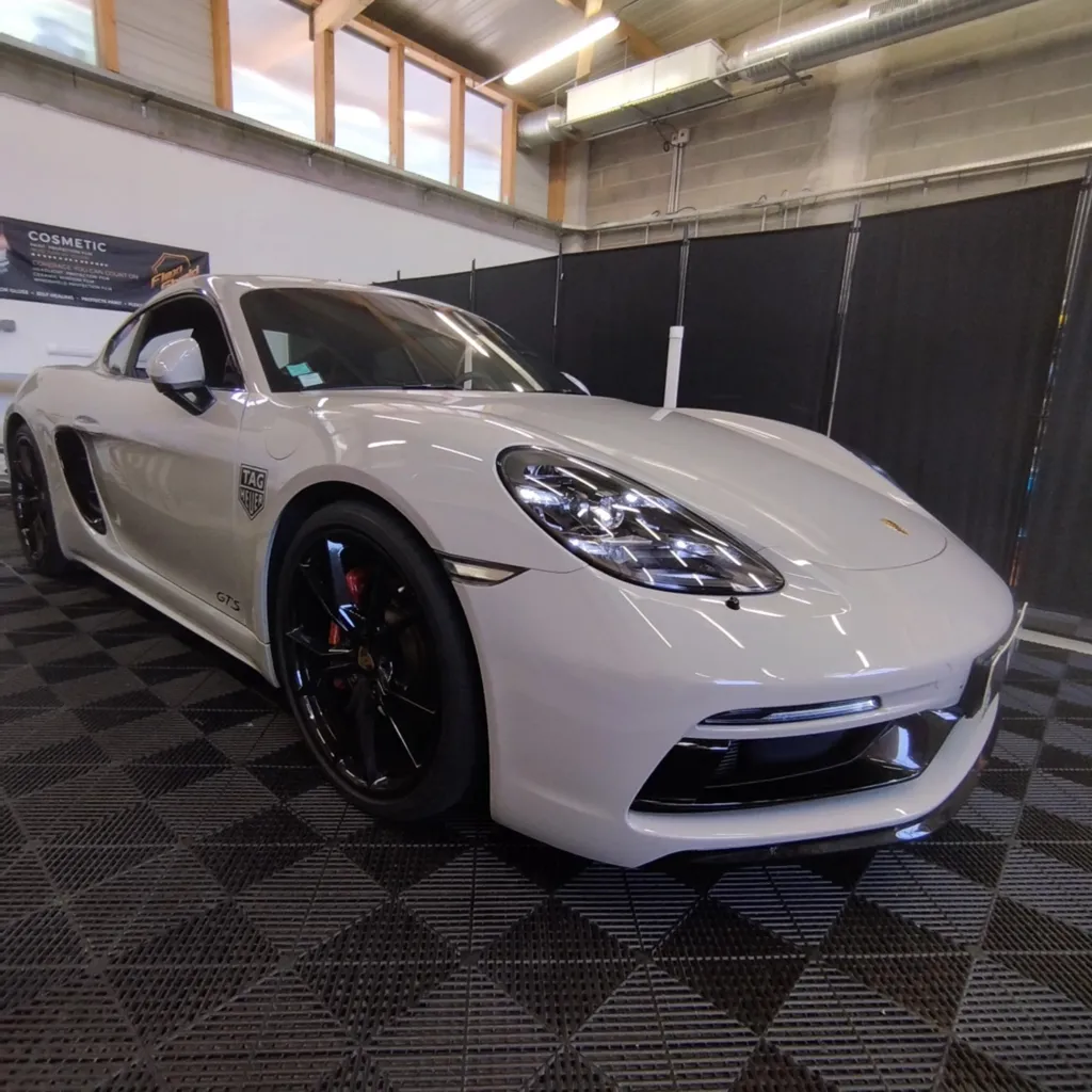 Pose de film de protection PPF FlexiShield sur ailes et bas de caisse d’une Porsche GTS à Clermont-Ferrand avec reproduction stickers Tag Heuer