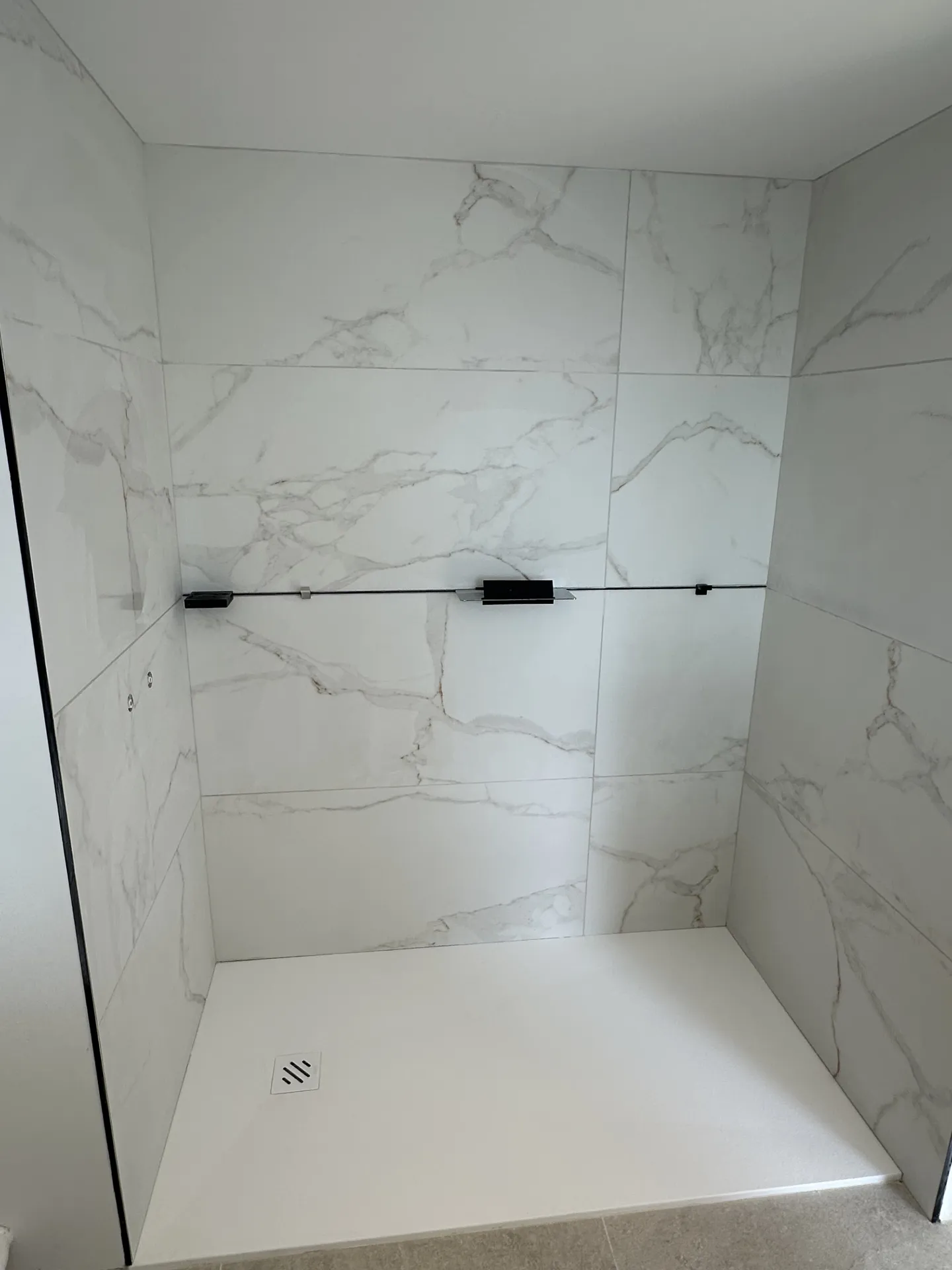 Rénovation d'une salle de bain sur le secteur de Rouen 76 avec pose d'un carrelage aspect marbre au mur.