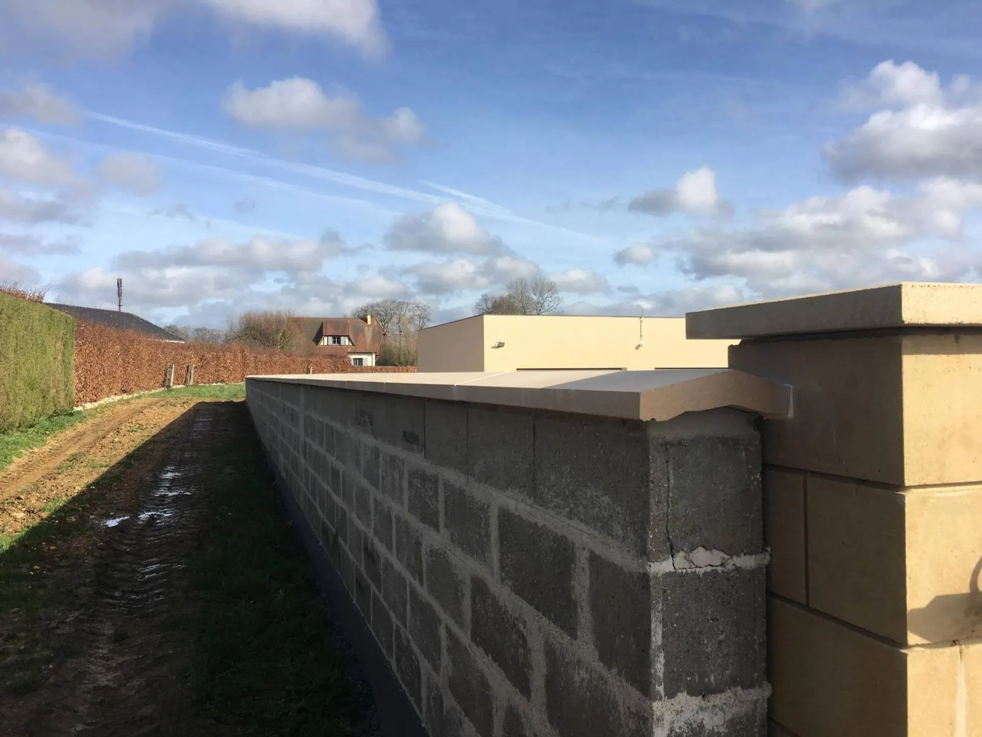 Réalisation de muret en agglos avec chapeau en pierre