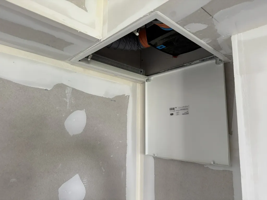 Intégration technique d'un kit VMC simple flux extra-plate de 74 mm logé sous un soffite de plafond sur mesure pour assurer le renouvellement de l'air sans perte de volume habitable.