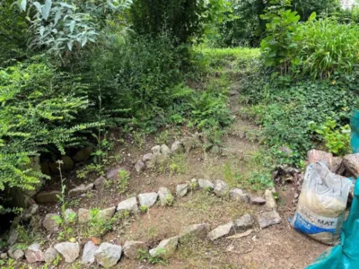 Réalisation de marches en poutres de chênes et bachage de talus