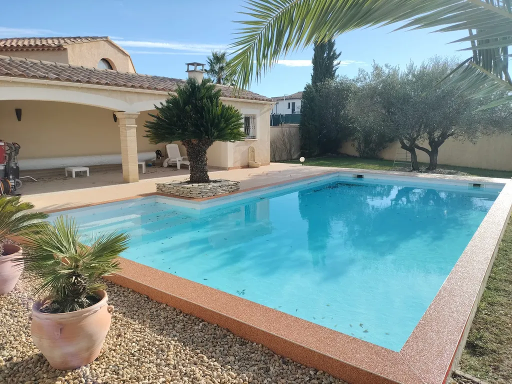 Rénovation de plage de piscine en moquette de pierre avec préparations techniques, finitions aluminium et motif décoratif à Codognan