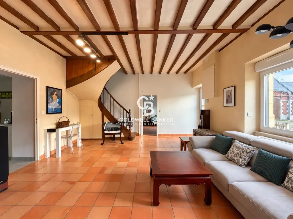 Séjour avec poutres apparentes, carrelage en terre cuite et escalier en bois, demeure principale du domaine près du Mans