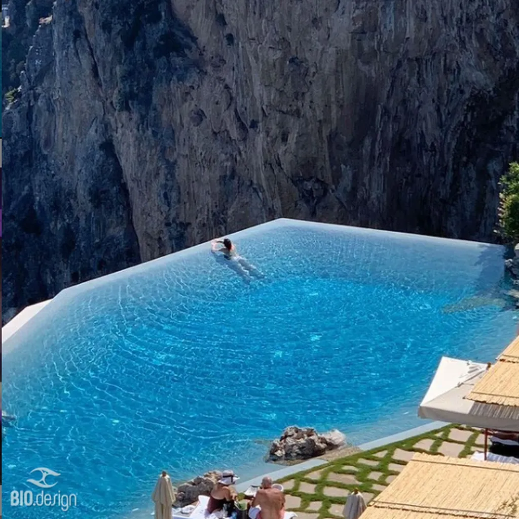 Création de piscine lagon à débordement avec plage immergée et vue panoramique en Suisse haut de gamme