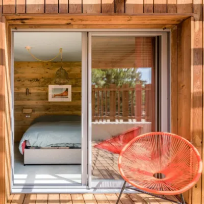 Chambre avec murs en bois chaleureux, mobilier sur-mesure et ambiance bord de mer, créant un espace cosy et élégant, par l’Atelier D. architecte d'intérieur à Bordeaux
