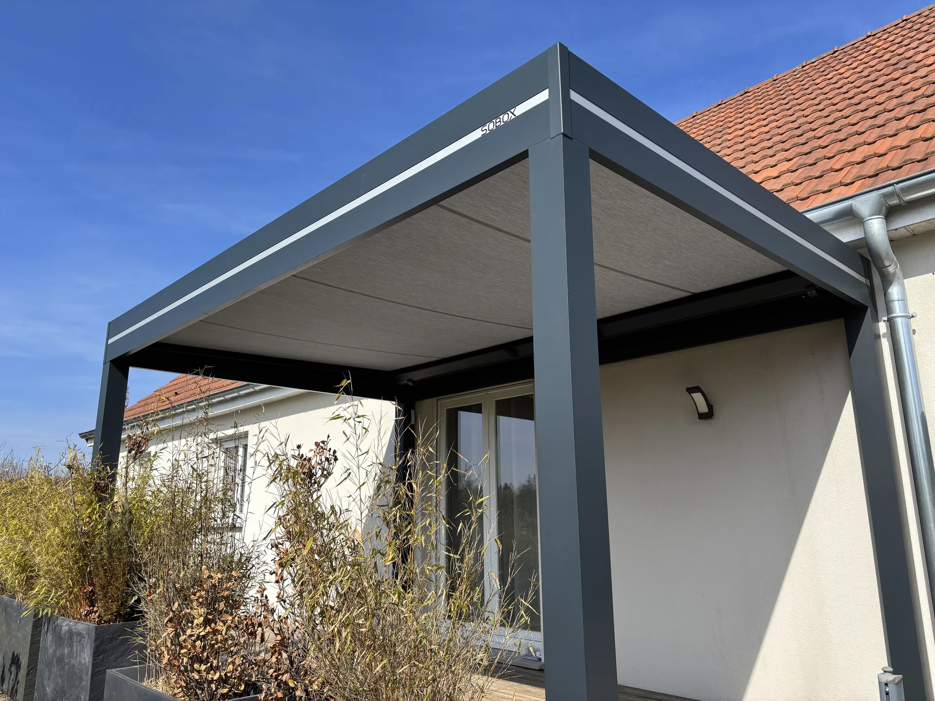 Réalisation d’une pergola store  dans le Territoire de Belfort à  Sermamagny 90300 coloris 7016, toiles Dickson imperméable couleur gris souris