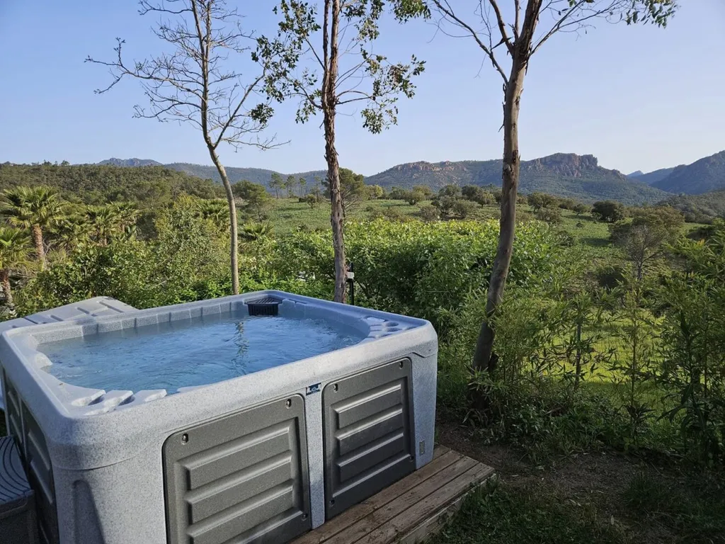Spa Raymond Le Spa Français 6 places installé en extérieur dans un environnement naturel avec vue dégagée sur la nature