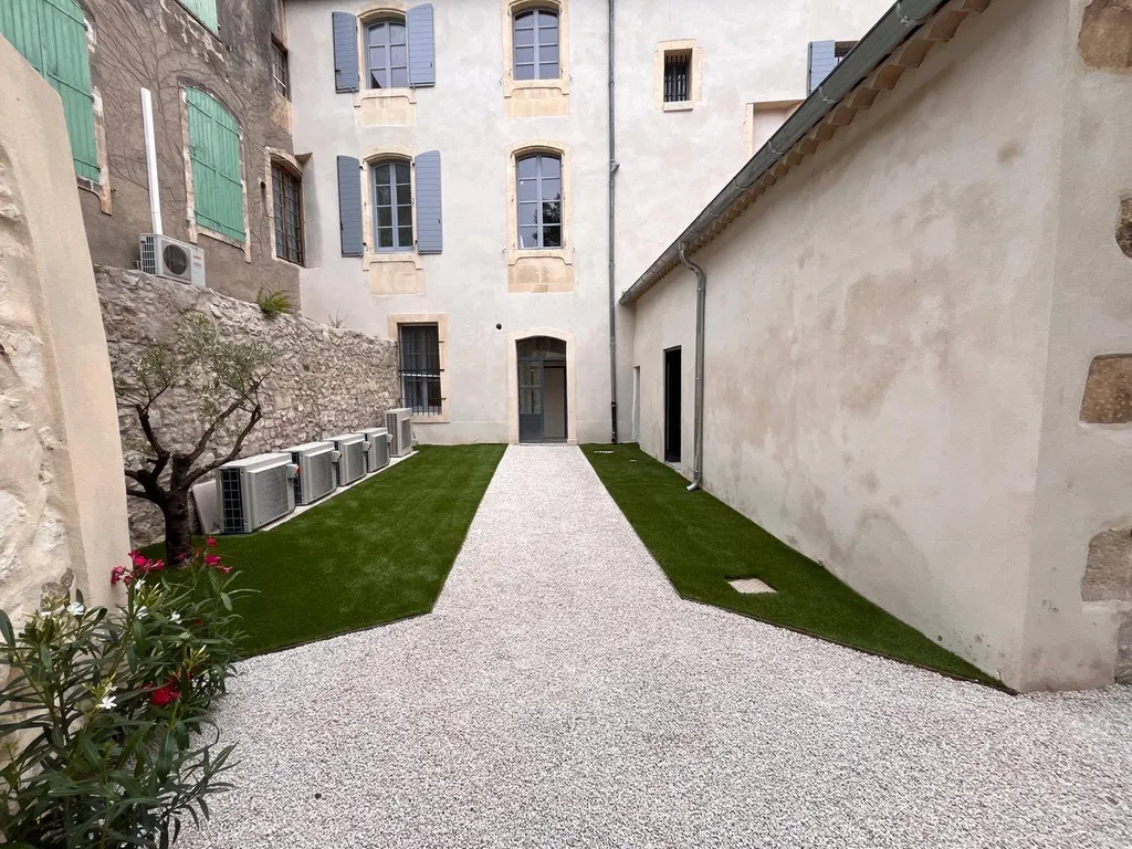 Aménagement extérieur à Maussane-les-Alpilles 13520, avec gazon synthétique, oliviers, lauriers et jasmins pour un jardin provençal esthétique et durable