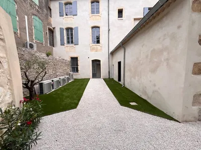 Aménagement extérieur à Maussane-les-Alpilles 13520, avec gazon synthétique, oliviers, lauriers et jasmins pour un jardin provençal esthétique et durable