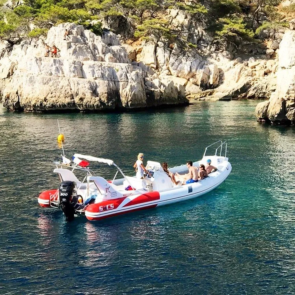 Semi-rigide de L'Eden Boat ancré dans une crique étroite et préservée des Calanques, inaccessible aux grands bateaux collectifs, eau turquoise et falaises blanches