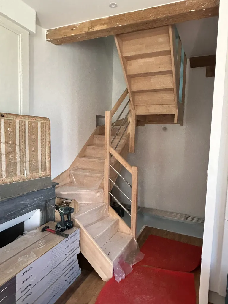 Pose de l’escalier intérieur en bois sur mesure lors de la rénovation de cette maison à Villefranche-sur-Saône
