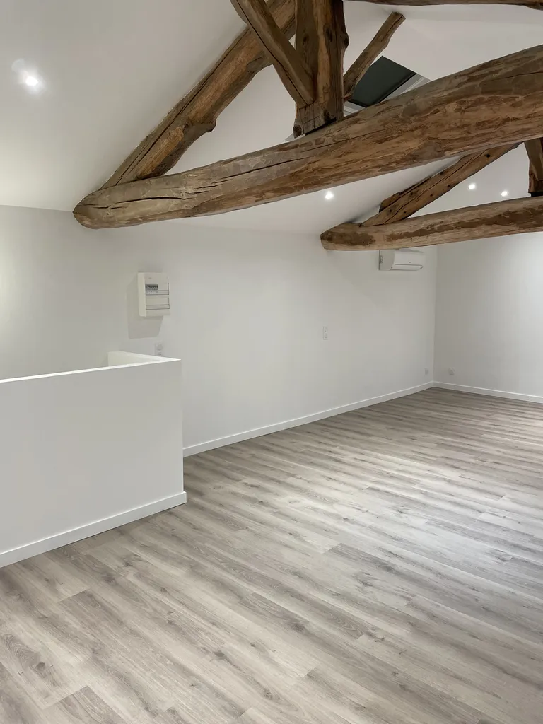 Combles aménagés avec climatisation et sol PVC imitation parquet dans une maison à Jassans-Riottier près de Trévoux