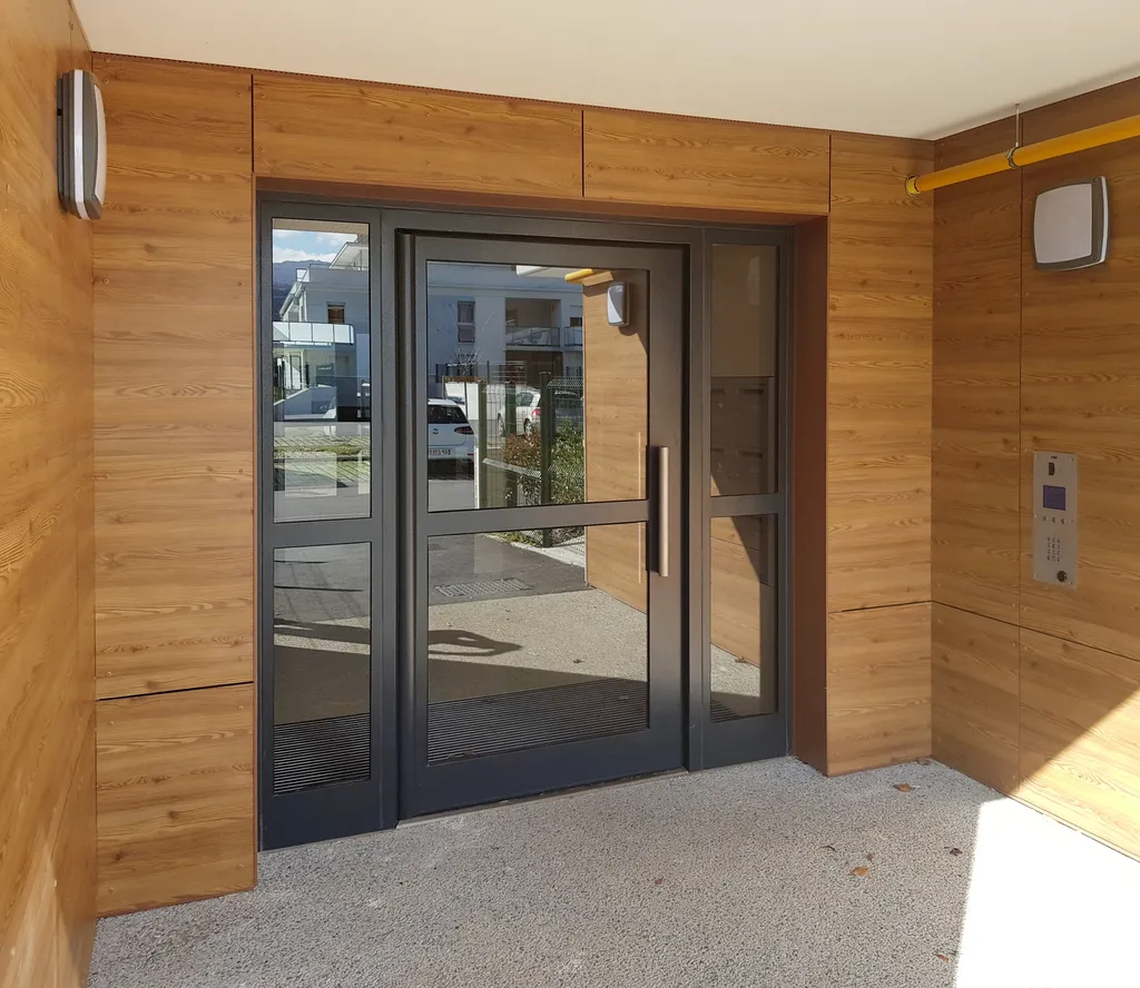 Porte de hall inox sur pivot pour copropriétés avec boîtes aux lettres