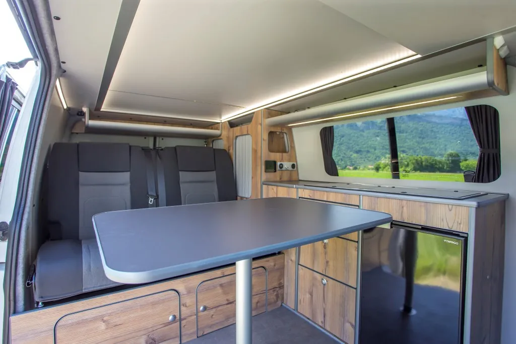 Aménagement intérieur sur-mesure VW Transporter T6 Court avec banquette Reimo et finition bois vieilli à Chambéry en Savoie