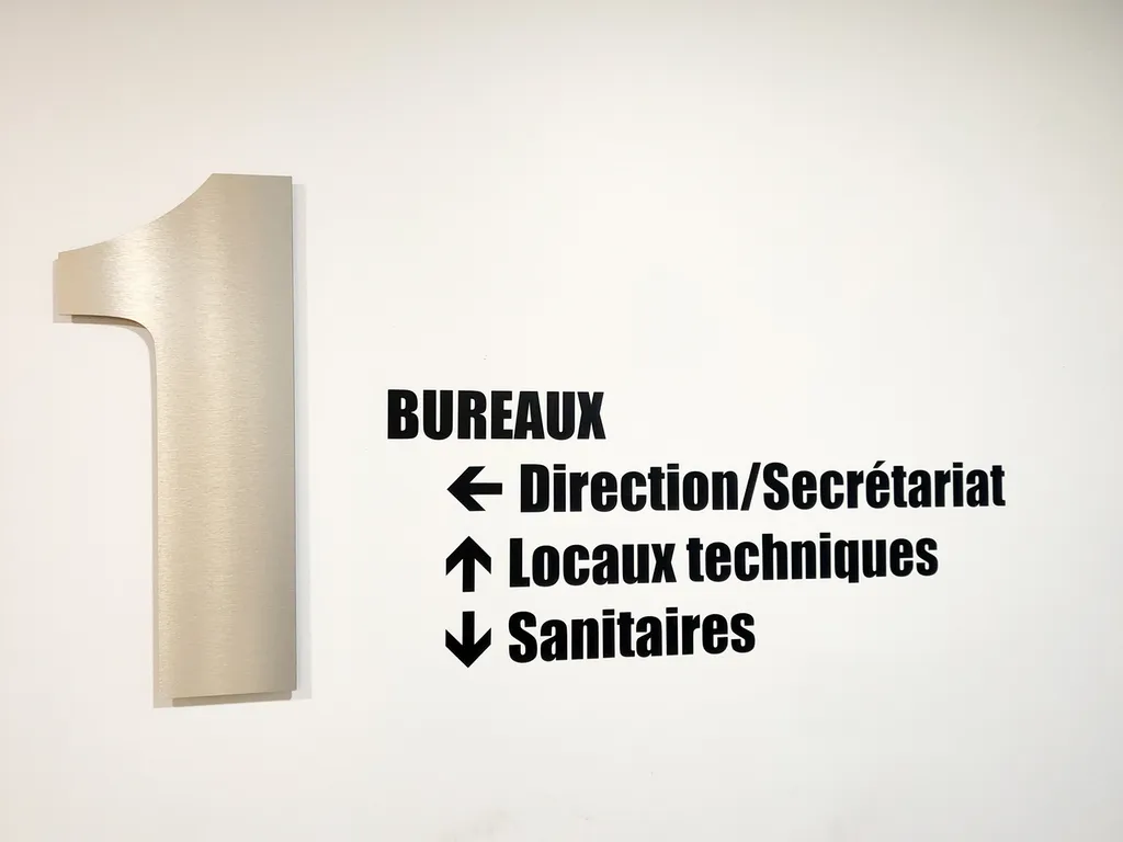 Signalétique intérieure et numéros gravés sur mesure pour bureaux, tables de travail et portes aux Archives départementales de l’Isère à Grenoble