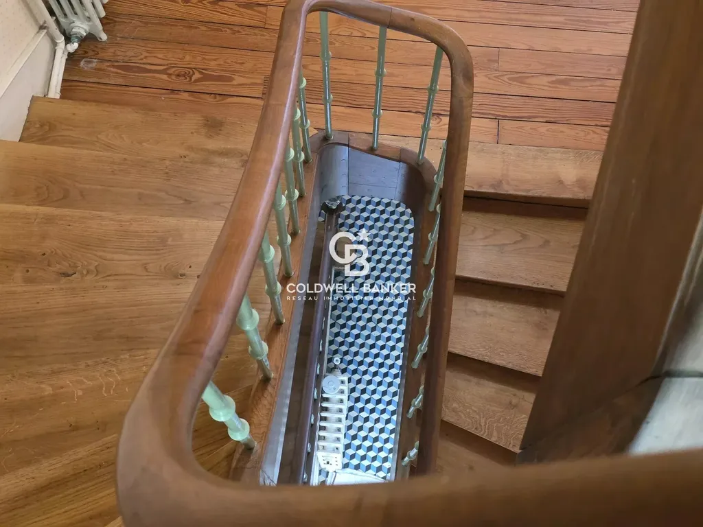 Vue plongeante sur l'escalier en bois, distribution sur trois niveaux