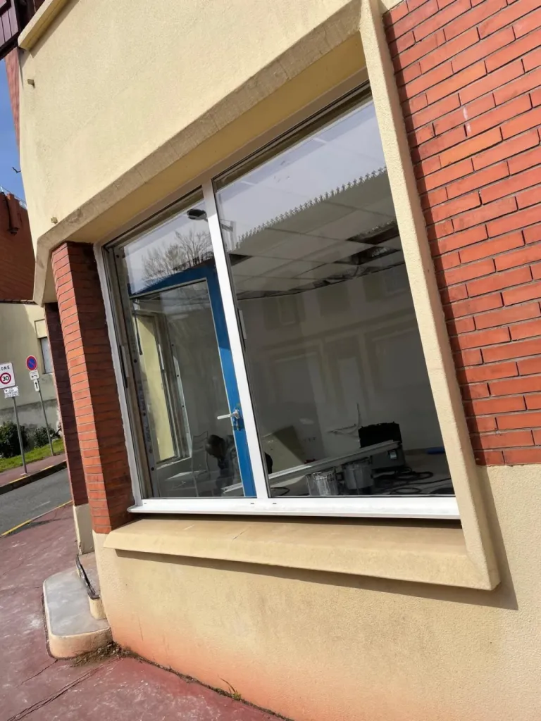 Pose de menuiseries aluminium : porte et grande fenêtre vitrée sur façade de bâtiment à Toulouse