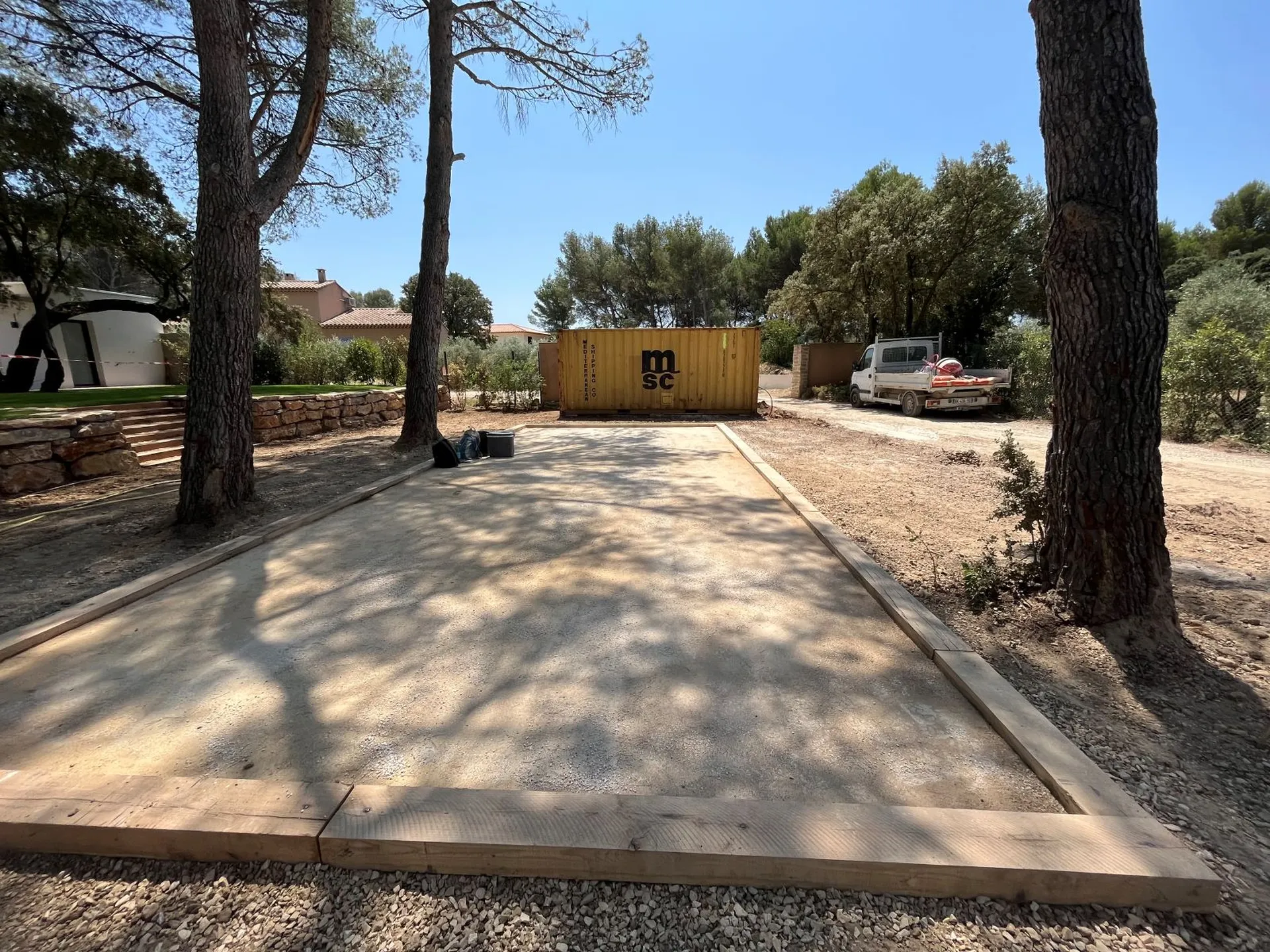 Création d’un terrain de pétanque sous une pinède pour une maison à Velaux