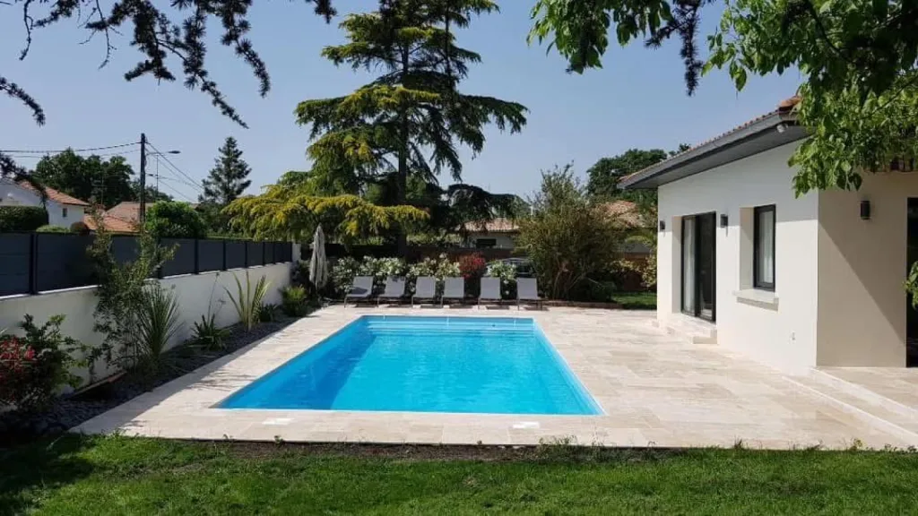 Vue de l'installation professionnelle d'une piscine en coque à Mios, montrant la mise en place de la coque dans le jardin.