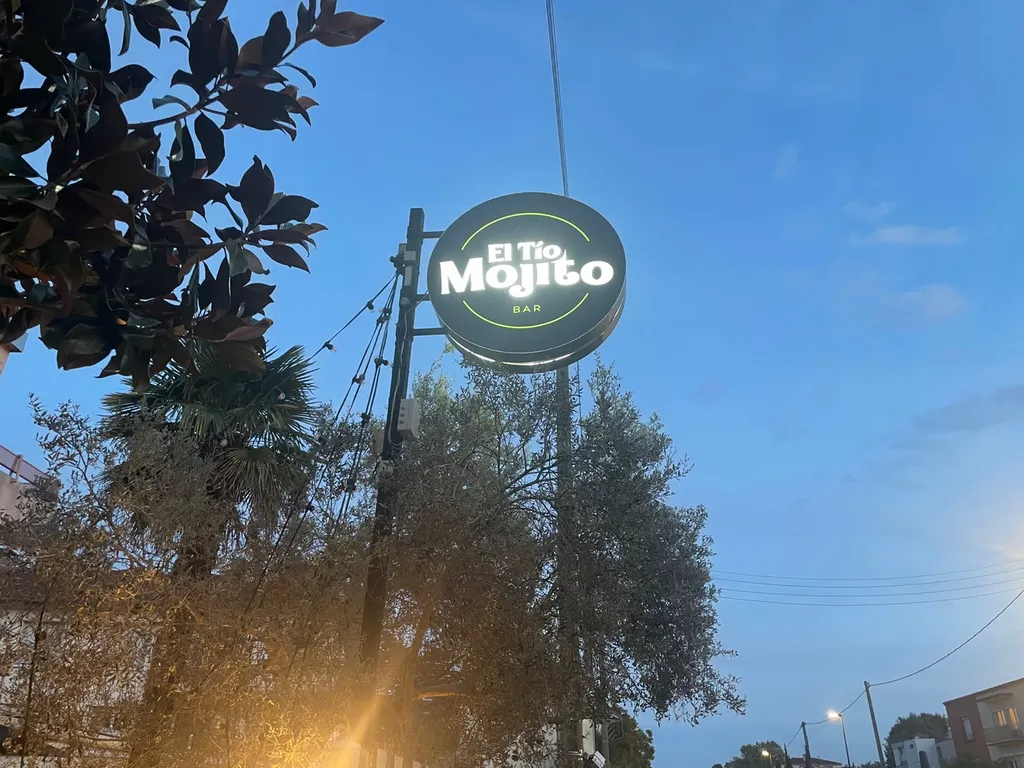 Installation d'une enseigne drapeau lumineuse ronde sur mât pour le bar El Tío Mojito par Fuzz Communication.
