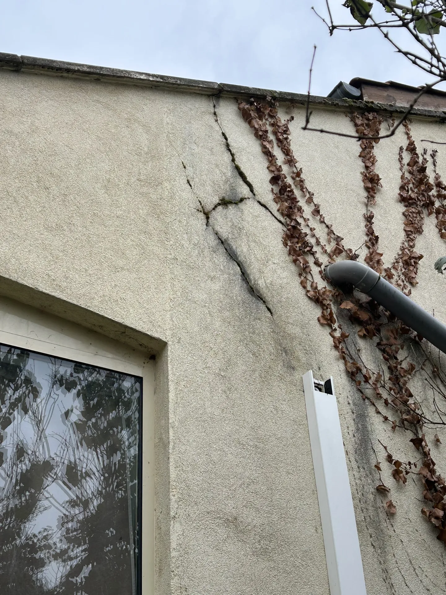 État initial de la façade d’une maison individuelle à Villefranche-sur-Saône, présentant des fissures structurelles profondes avant l'intervention de consolidation.