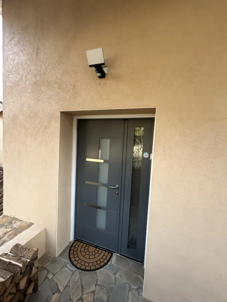 Nouvelle porte d’entrée en aluminium vue extérieure, améliorant la sécurité, l’isolation thermique et l’esthétique de la maison