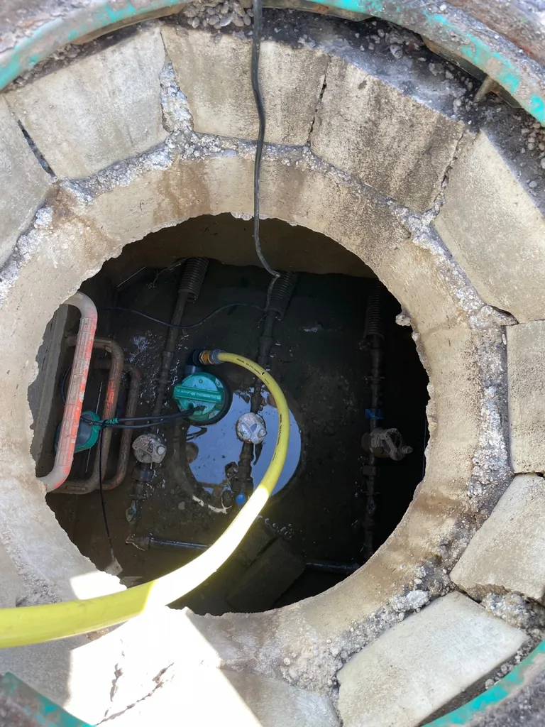 Intervention pour une fuite d'eau à Craponne dans le regard extérieur, au niveau des compteurs d'eau. Vidange du regard rempli d'eau avec une pompe pour réaliser l'intervention