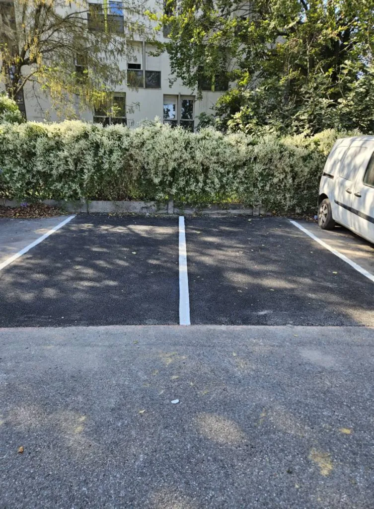 Entreprise de terrassement dans l'Ain pour démolition d'un ancien enrobé pour mise en œuvre d'un nouveau enrobé et marquage au sol dans un parking de copropriété à Divonne-les-Bains
