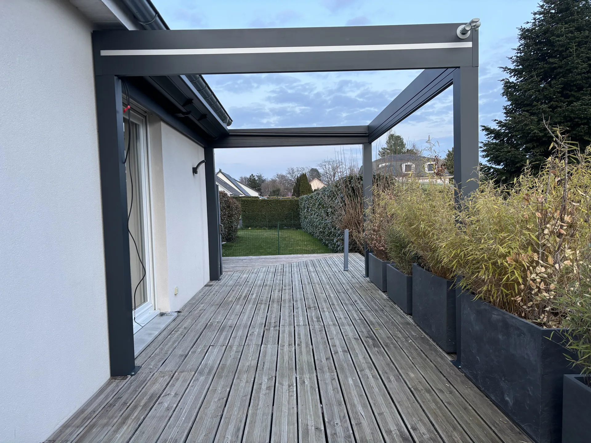 Réalisation d’une pergola store  dans le Territoire de Belfort à  Sermamagny 90300 coloris 7016, toiles Dickson imperméable couleur gris souris