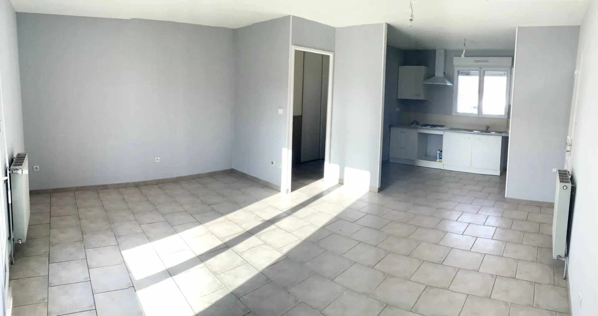 Une cuisine aménagée équipée donnant sur un séjour