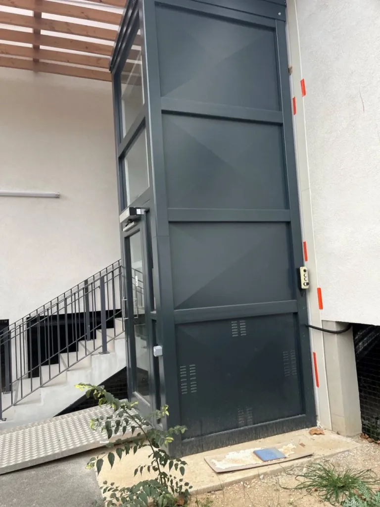 A Saint-Cannat, l'élévateur vertical extérieur VIMEC E10 a une face tôlée côté moteur et 3 faces vitrées