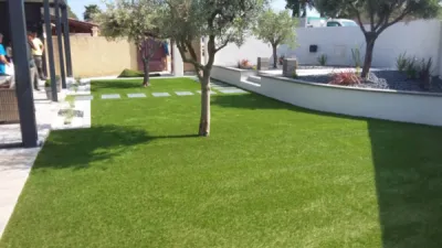 Pose d'un gazon artificiel sur terre dans un jardin contemporain Pose d'un gazon artificiel sur terre dans un jardin contemporain