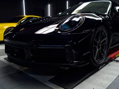 Application précise du PPF film de protection sur les ailes avant de la Porsche 992 Turbo S pour une finition invisible.