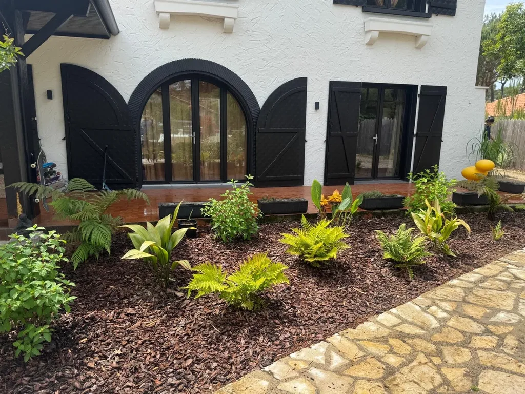 Création de massif paysager avec paillage et plantes variées à Mimizan