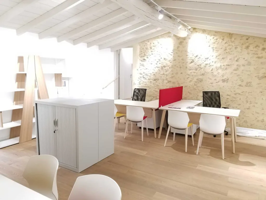 Réhabilitation de 200 m² de bureaux à Cheval-Blanc avec table de réunion 20 places, cafétéria colorée et design bois/blanc chaleureux