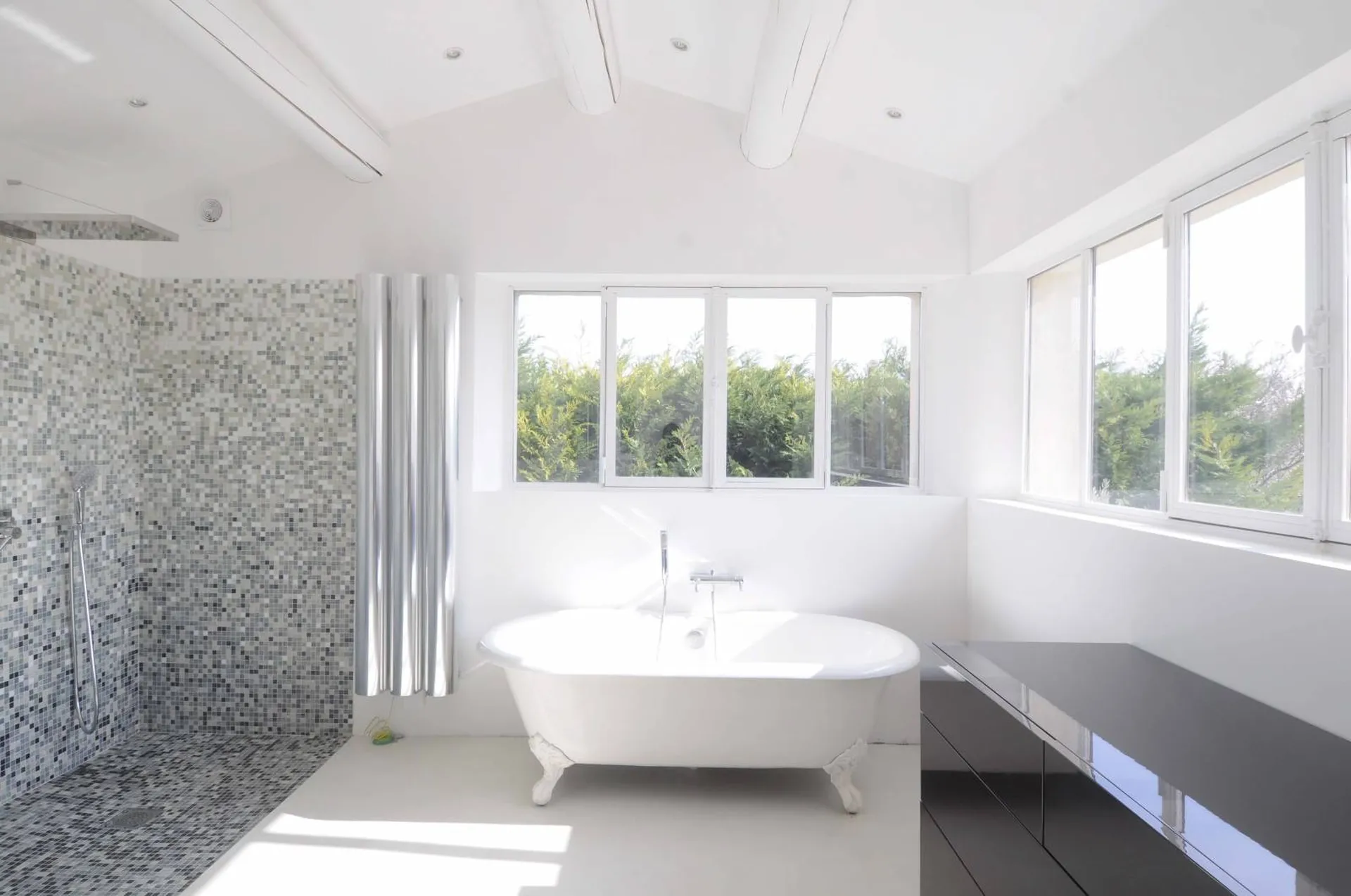 Elégante salle de bain avec baignoire Ilot et verrière de style atelier sur la construction d'une maison individuelle neuve