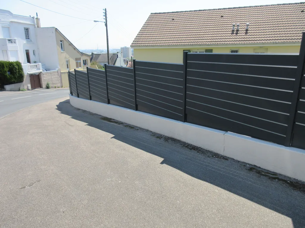 Pose de clôture en Aluminium sur le mur d'une propriété de particuliers à Mont Saint Aignan en Seine-Maritime 76