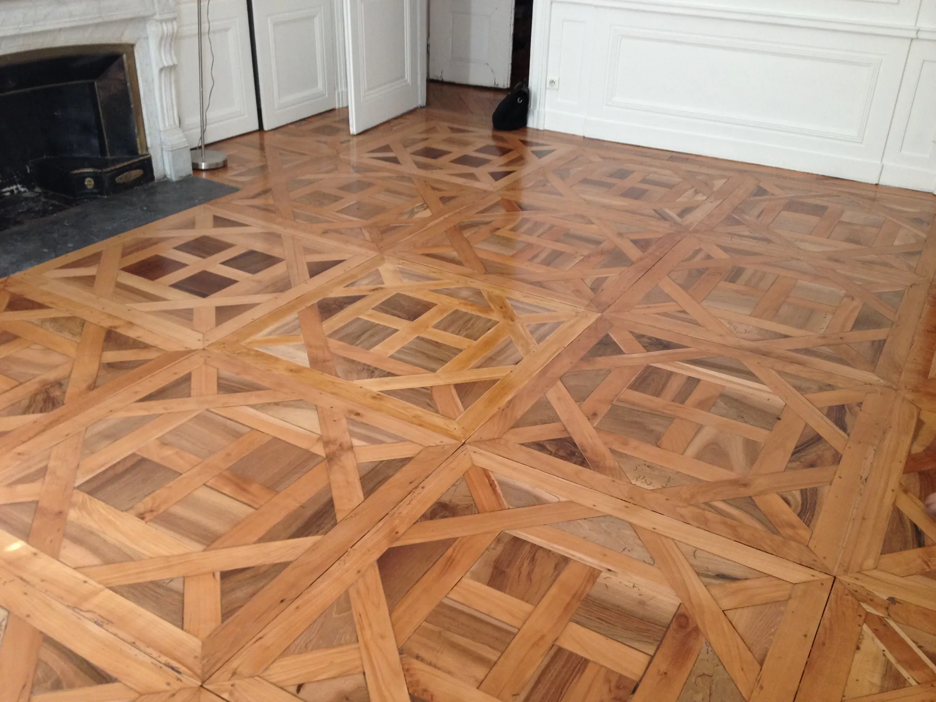 Parquet ancien type Versailles en 3 essences de bois poncé et vitrifié pour révéler toute l’élégance du bois dans cet appartement haussmannien à Lyon