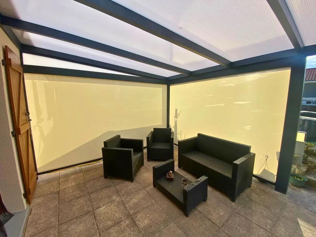 Pergola en aluminium sur-mesure avec toiture panneaux polycarbonate et store zip à Pont-du-Château près de Clermont-Ferrand (63)